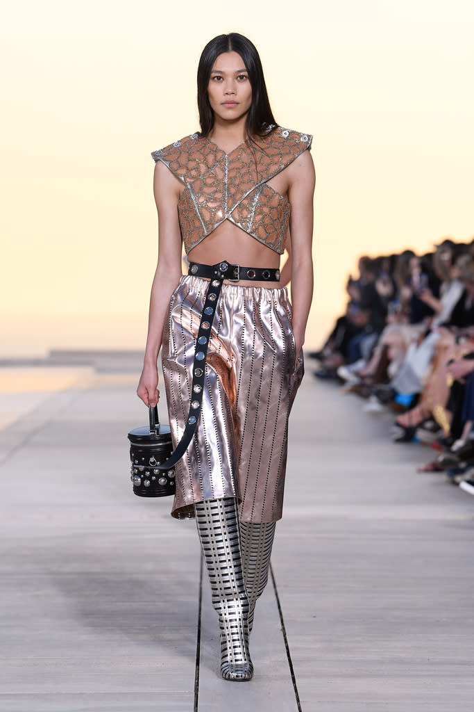 <p>Fidèle à lui-même, Nicolas Ghesquière présentait des looks hybrides célébrant une allure de conquérante des temps modernes. Bustier à effet lamé, cape posée négligemment sur les épaules, harnais en cuir se mêlent aux influences biker et à l’univers sport nautique pour des silhouettes futuristes et infiniment moderne à la fois. Le cuir rutilant contraste avec du denim brut, des broderies métalliques et du lin aérien pour des silhouettes riches et lumineuses.</p><br>