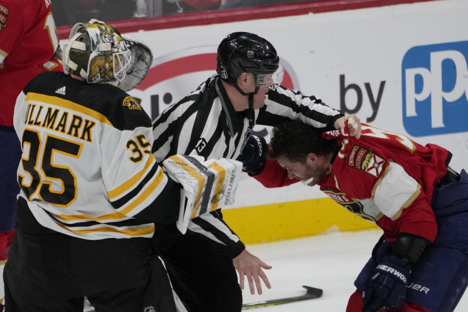 Florida Panthers left wing Matthew Tkachuk (19) his held back after exchanging punches with Boston Bruins goaltender Linus Ullmark (35) during the third period of Game 4 of an NHL hockey Stanley Cup first-round playoff series, Sunday, April 23, 2023, in Sunrise, Fla. (AP Photo/Marta Lavandier)