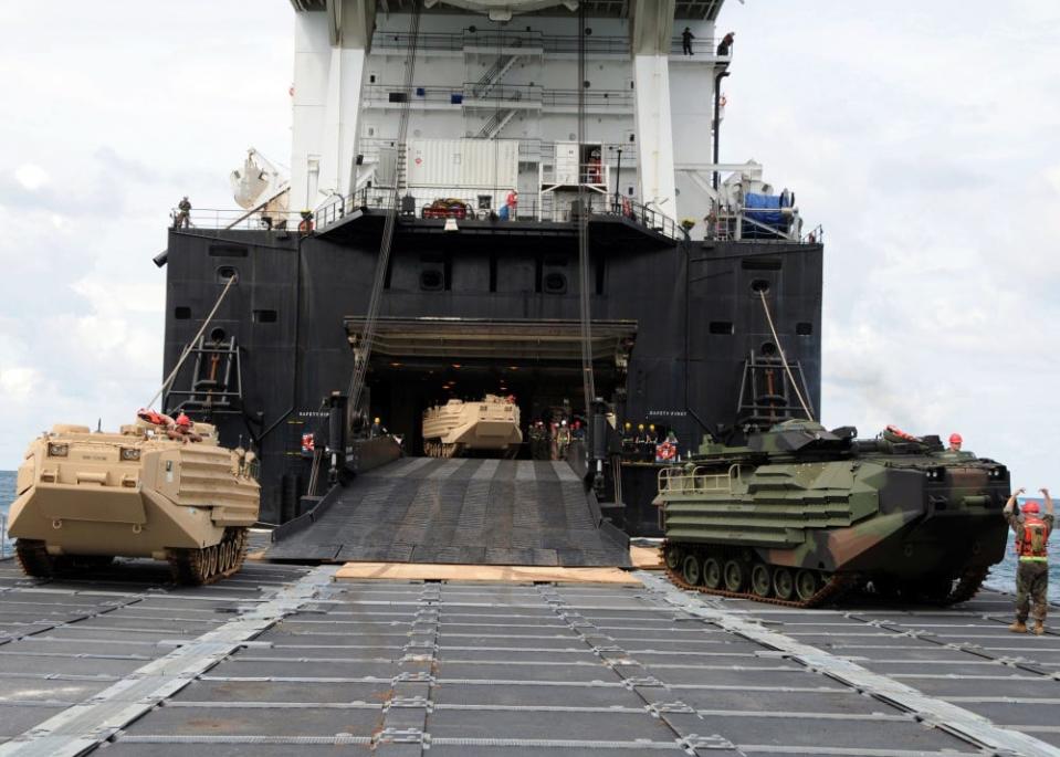 Marine Amphibious Assault Vehicles roll down the ramp of the Military Sealift Command Marine Corps roll-on.roll-off ship USNS 1st Lt Baldomero Lopez