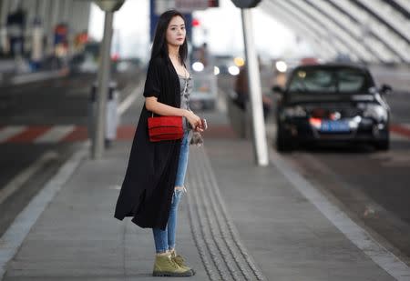 Interior designer Zheng Yue poses for a picture at the airport in Chengdu, Sichuan province, China, September 14, 2017. Picture taken September 14, 2017. REUTERS/John Ruwitch