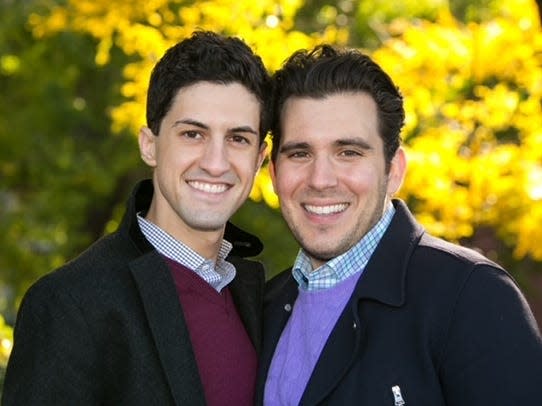 Corey Briskin, left, and Nicholas Maggipinto, right, smile in front of foliage.