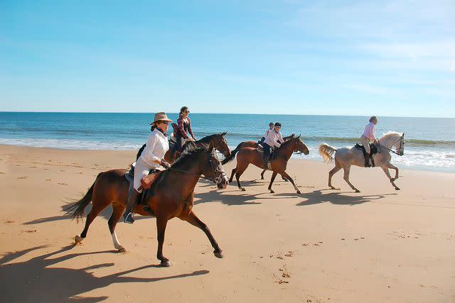 <p>Courtesy of Catherine Buni</p> Equiberia riders breaking into a gallop along a beach on the Costa de la Luz.