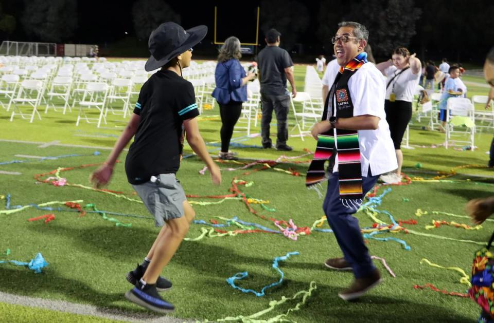 El concejal de Fresno Miguel Arias y su hijo, Diego, bailan al final de la  inaugural Celebración de Reconocimiento a las Preparatorias Latinas en el McLane High Stadium, el 4 de junio de 2023.