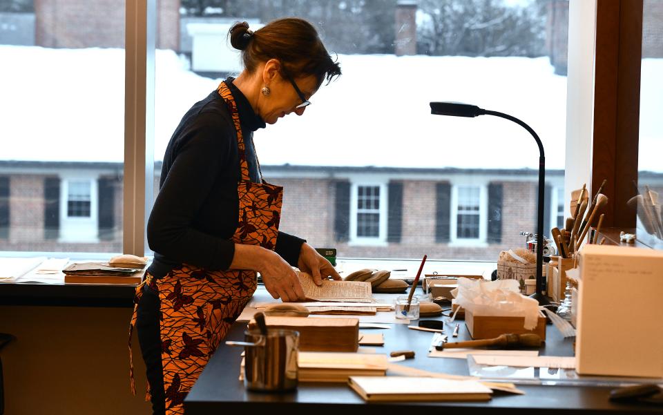 American Antiquarian Society Chief Conservator Babette Gehnrich of Paxton performs a paper repair on an 1911 trade catalogue in the conservation lab.