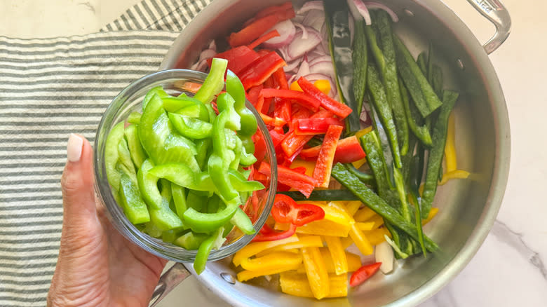 adding green pepper to skillet