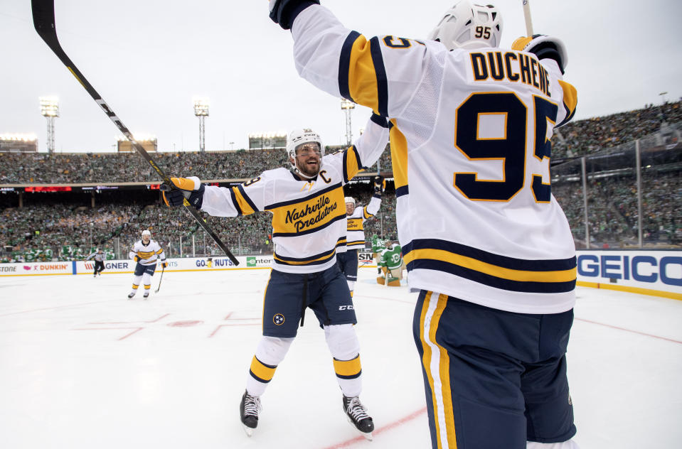 Nashville Predators left wing Filip Forsberg (9) celebrates with center Matt Duchene (95) after Duchene's goal against the Dallas Stars in the first period of the NHL Winter Classic hockey game between the Dallas Stars and the Nashville Predators at the Cotton Bowl, Wednesday, Jan. 1, 2020, in Dallas. (AP Photo/Jeffrey McWhorter)