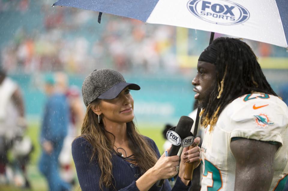 MIAMI GARDENS, FL - DECEMBER 11: FOX Sports field reporter Holly Sonders interviews Miami Dolphins Running Back Jay Ajayi (23) in the rain on the field after the NFL football game between the Arizona Cardinals and the Miami Dolphins on December 11, 2016, at the Hard Rock Stadium in Miami Gardens, FL. (Photo by Doug Murray/Icon Sportswire via Getty Images)