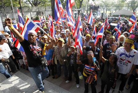 Anti-government protesters hold Thai national flags during a public seminar where protest leader and former deputy prime minister Suthep Thaugsuban is speaking at, at Thammasat University in Bangkok December 14, 2013. REUTERS/Chaiwat Subprasom