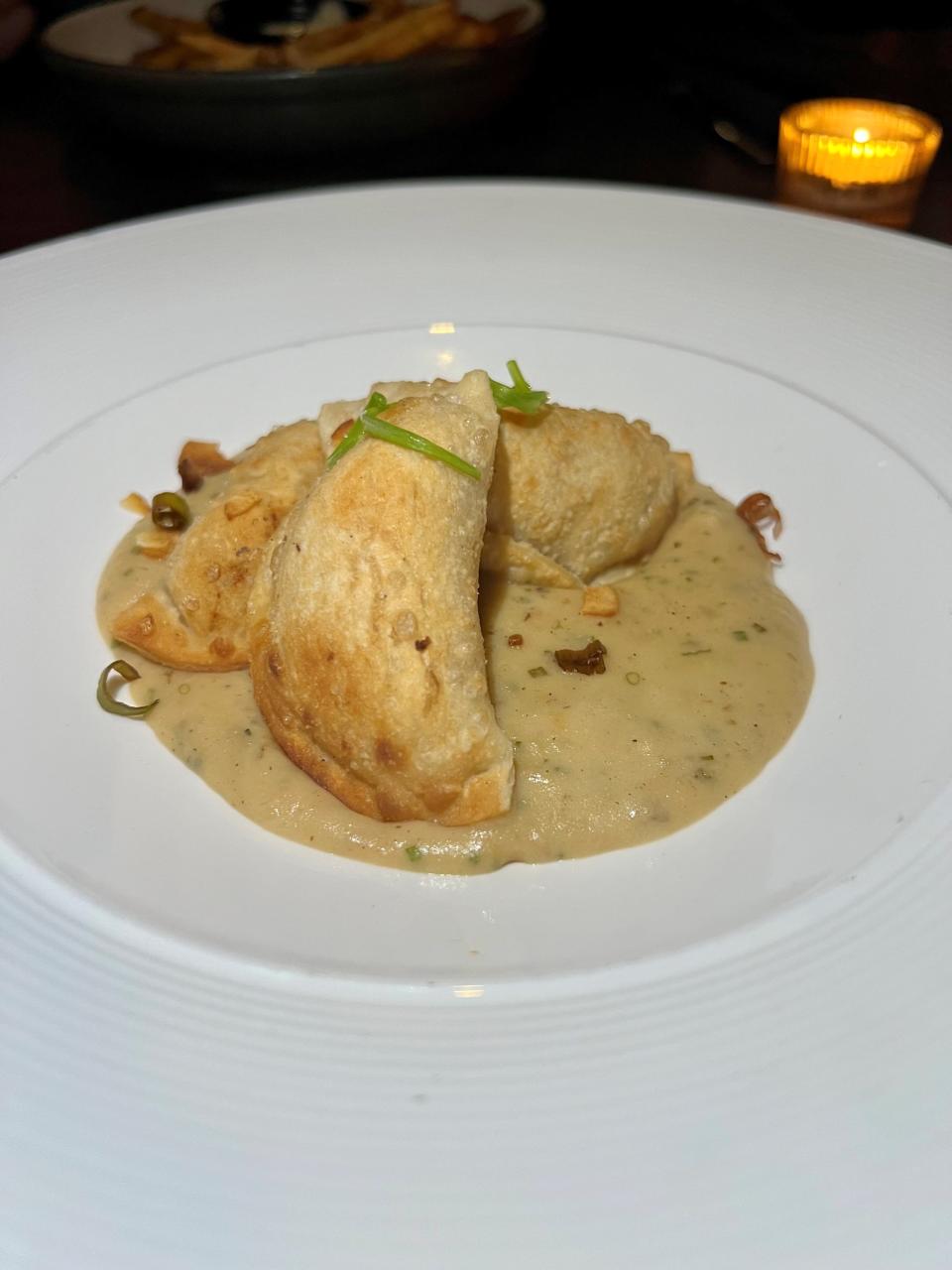 Pierogis with carmalized onion, white cheddar, potato leek emulsion and crispy garlic at Sinema in Nashville on March 30, 2024