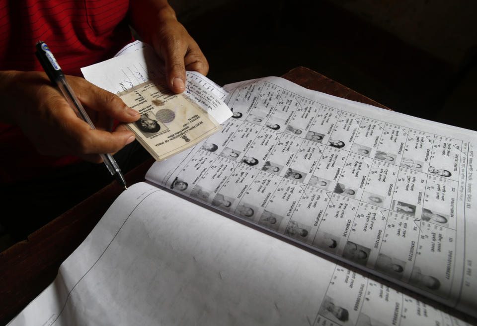 An election official checks the identity of a voter during the first phase of elections in Agartala, in the northeastern state of Tripura, India, Monday, April 7, 2014. (AP Photo/Saurabh Das)