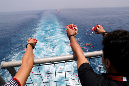 Families and colleagues of passengers and crew of Lion Air flight JT610 throw flowers and petals from the deck of Indonesia Navy ship KRI Banjarmasin as they visit the site of the crash to pay their tribute, at the north coast of Karawang, Indonesia, November 6, 2018. REUTERS/Beawiharta