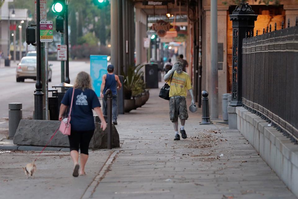 Street performer Eddie Webb walks through the nearly deserted French Quarter looking to make money in New Orleans, Sunday, March 22, 2020.