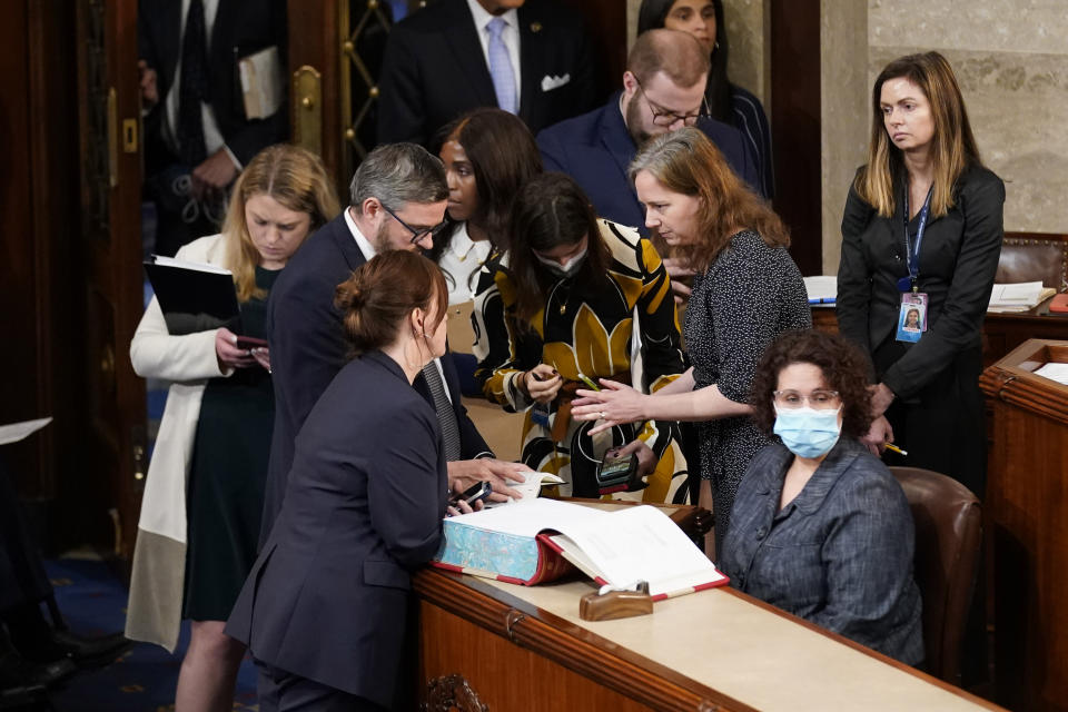 House staff consult books in the House chamber as the House meets for a second day to elect a speaker and convene the 118th Congress in Washington, Wednesday, Jan. 4, 2023. (AP Photo/Andrew Harnik)