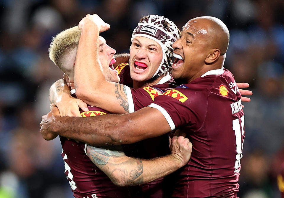 Cameron Munster, Kalyn Ponga and Felise Kaufusi embrace and celebrate victory at full-time.