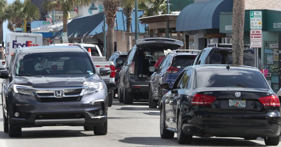 New Smyrna Beach drivers look for parking spaces on busy Flagler Avenue, Friday, Feb. 10, 2023.