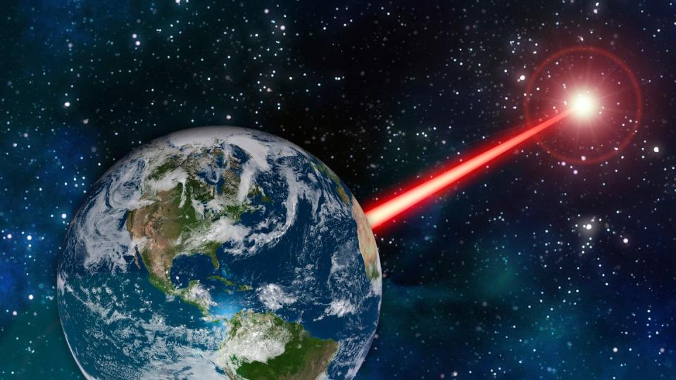 Eine undatierte grafische Darstellung zeigt einen gebündelten Laserstrahl, der von der Erde aus weit in den Weltraum reicht. Foto: MIT News/dpa