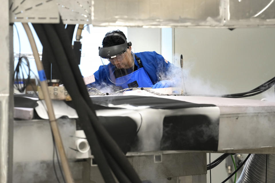 A magnet test engineer checks fluid levels in a testing device at Commonwealth Fusion Systems, in Devens, Mass., Wednesday, Oct. 11, 2023. Commonwealth is trying to create fusion inside what's called a tokamak. Nuclear fusion, which would be a new source of carbon-free energy, melds two hydrogen atoms together to produce a helium atom and a lot of energy. (AP Photo/Steven Senne)