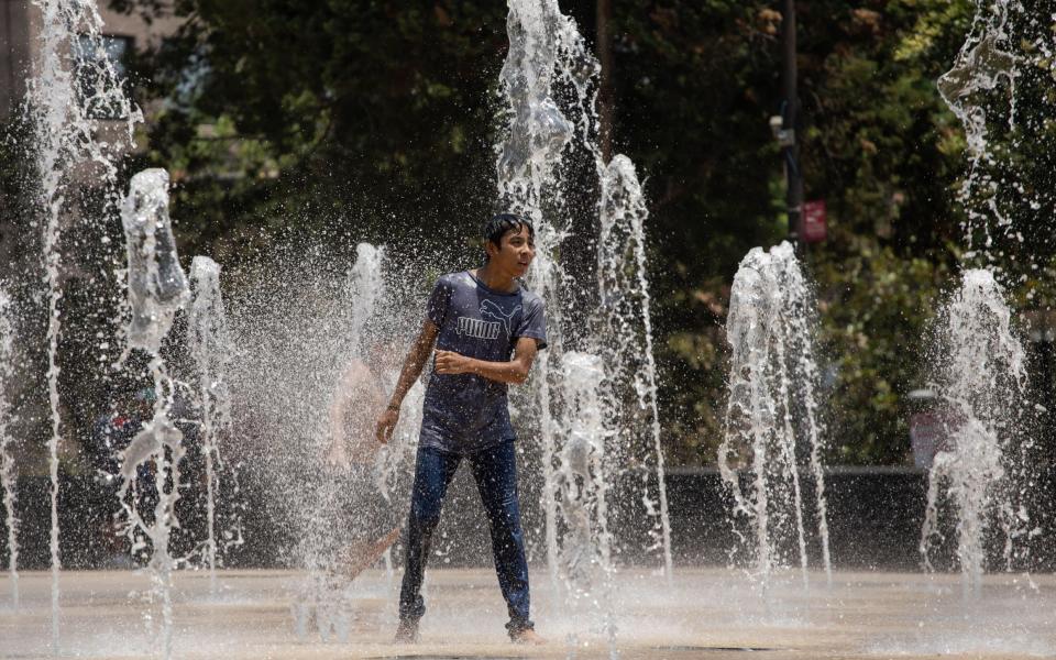 A young man cools off during the heat wave season in Plaza de la Republica square, in Mexico City