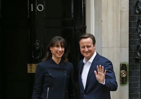 Britain's Prime Minister David Cameron waves as he arrives with his wife Samantha at Number 10 Downing Street in London, Britain May 8, 2015. REUTERS/Phil Noble