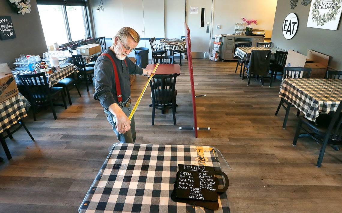 In 2020 Roger Pearson measures inside Hill’s Restaurant & Lounge in Kennewick while trying different table layouts to meet the state’s expected reopening requirements for dining rooms during the coronavirus pandemic. His wife, Nancy Galstad, owns the popular restaurant.
