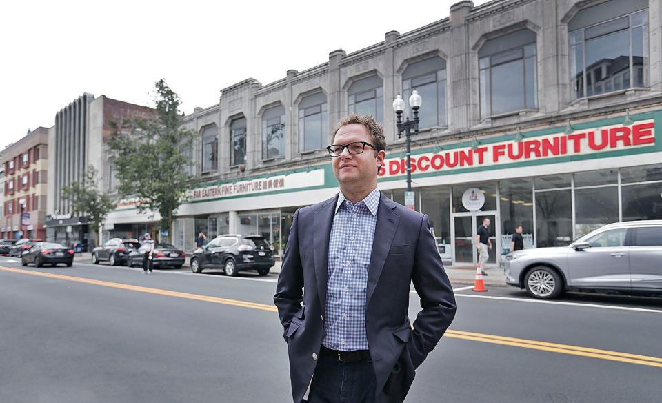 Developer Sam Slater stands in front of a two-story building known locally as the arcade building on Hancock Street in downtown Quincy. Slater plans to turn 1469 Hancock St., the current home of Bob's Discount Furniture, into a 15-story, 204-unit residential tower with retail space.