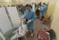 Health care workers take nasal swab samples from Palestinians at a COVID-19 testing center, in the Palestine Medical Complex, in the West Bank city of Ramallah, Tuesday, March 2, 2021. (AP Photo/Nasser Nasser)