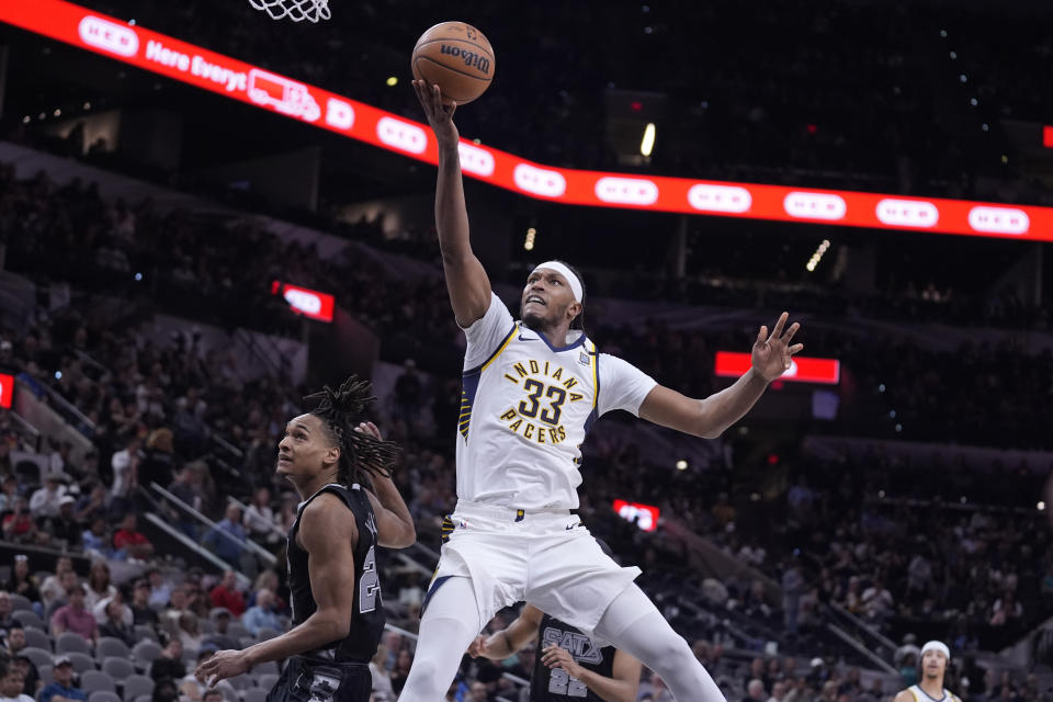 Indiana Pacers center Myles Turner (33) scores past San Antonio Spurs guard Devin Vassell, left, during the second half of an NBA basketball game in San Antonio, Sunday, March 3, 2024. (AP Photo/Eric Gay)