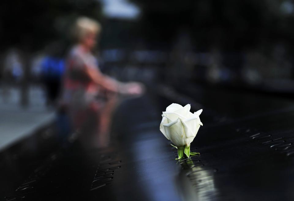 A woman pauses at the South reflecting pool at the 9/11 Memorial during ceremonies marking the 12th anniversary of the 9/11 attacks on the World Trade Center in New York, September 11, 2013. (REUTERS/Stan Honda)