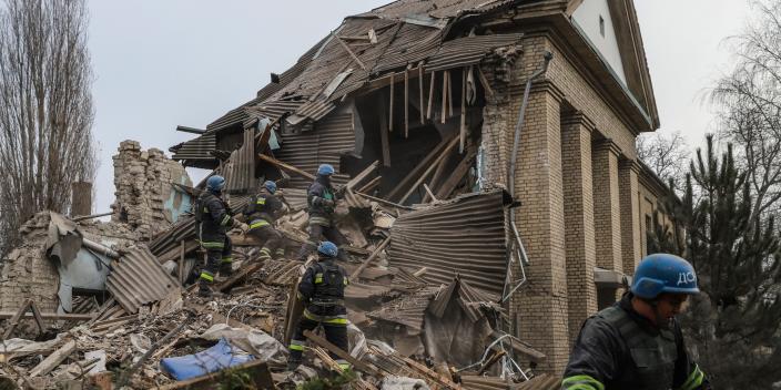 Firefighters stand among the rubble of a damaged hospital in Vilniansk, Ukraine.