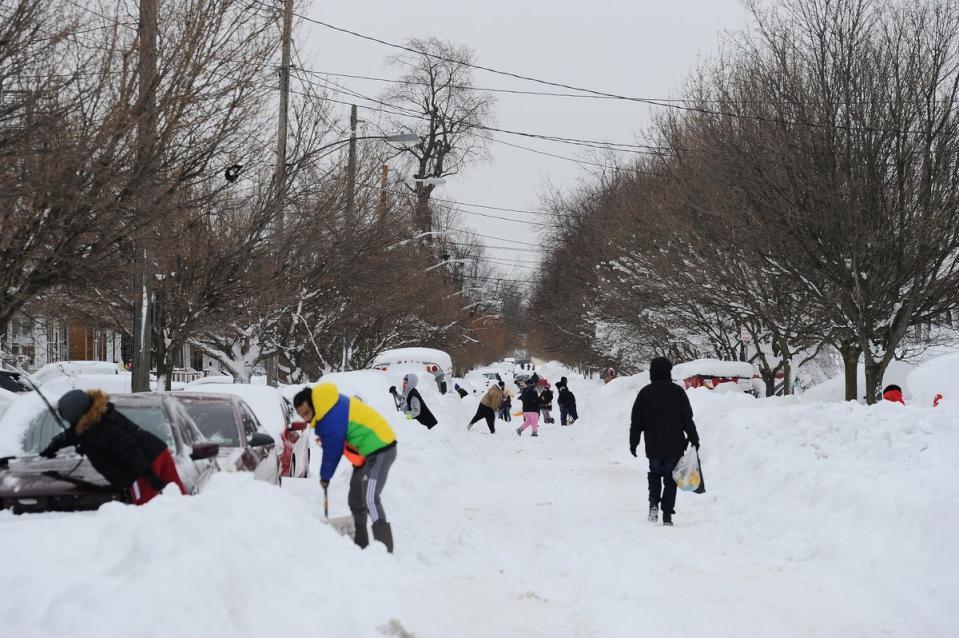 Buffalo residents work to clear snow from the streets on 27 December (Getty Images)