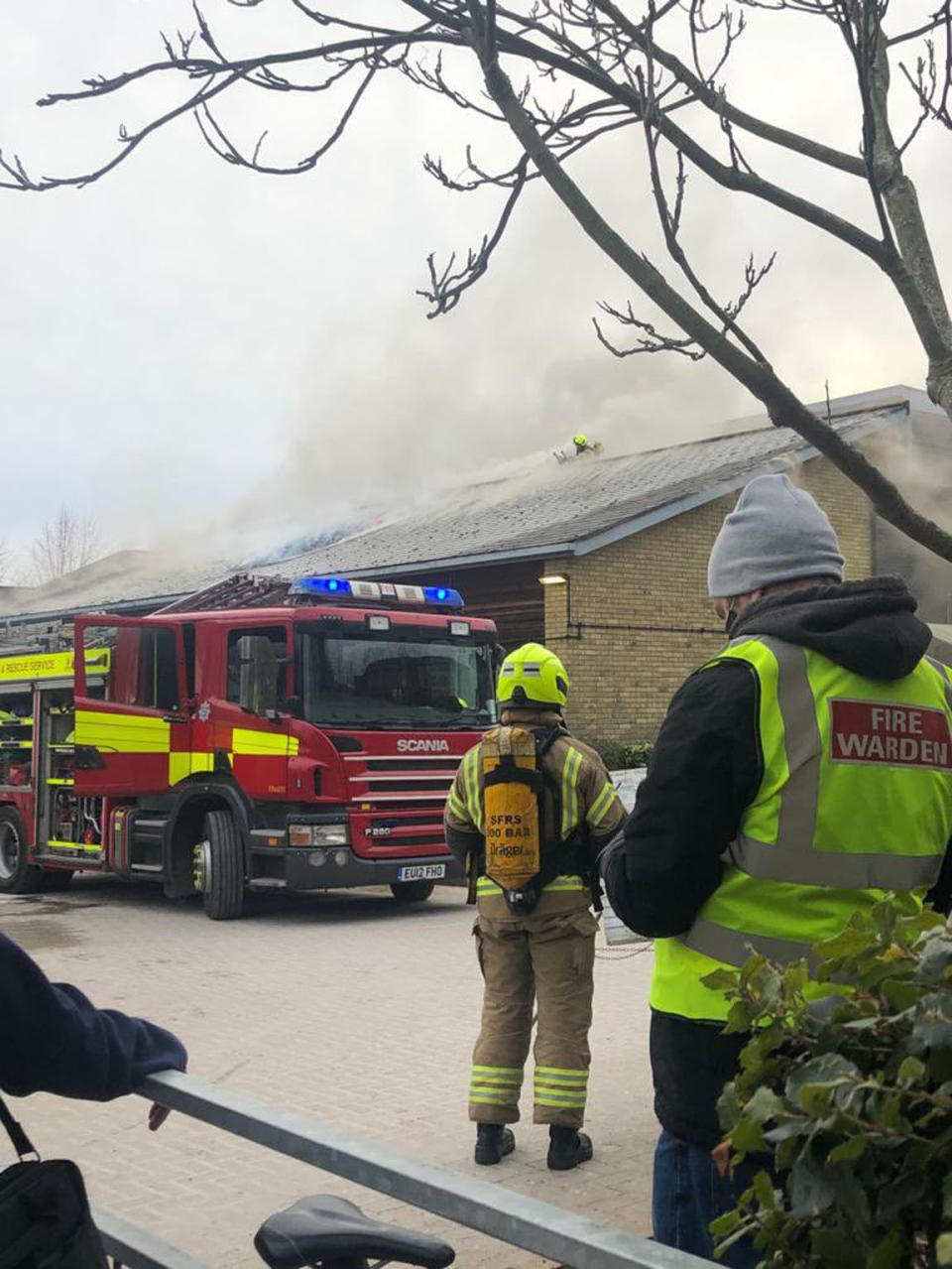 Handout photo dated 13/02/21 issued by @AboutTD on Twitter showing Surrey Fire and Rescue Service officers and vehicles at Emberbrook Community Centre, in Raphael Drive, Thames Ditton, which was being used as a vaccination centre but had to be evacuated after a fire broke out in the building. Issue date: Saturday February 13, 2021.