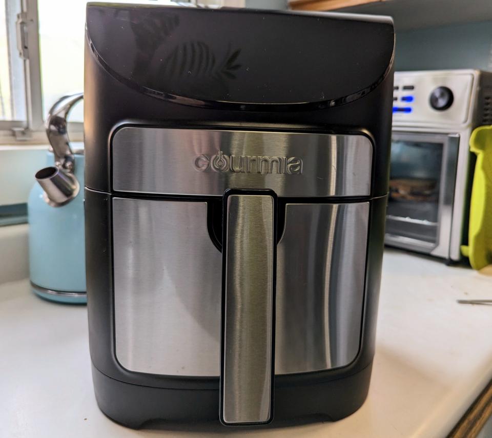 silver and black air fryer sitting on a kitchen counter