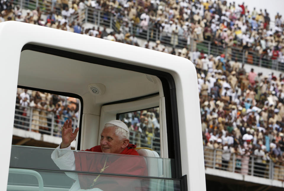 FILE - Pope Benedict XVI waves to faithful as he leaves after a special mass at the Amadou Ahidjo stadium, in Yaounde, Cameroon, March 19, 2009.Pope Emeritus Benedict XVI, the German theologian who will be remembered as the first pope in 600 years to resign, has died, the Vatican announced Saturday. He was 95. (AP Photo/Rebecca Blackwell, File)