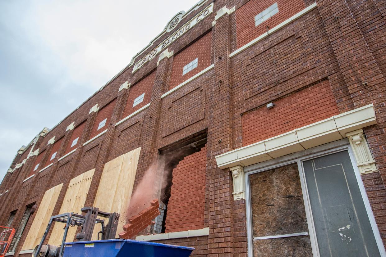 A chunk of bricks falls into a container as workers start clearing the windows of Ward Baking Co. building along Portage Avenue in South Bend. Much of the past year has been spent working on the inside of the historic building.