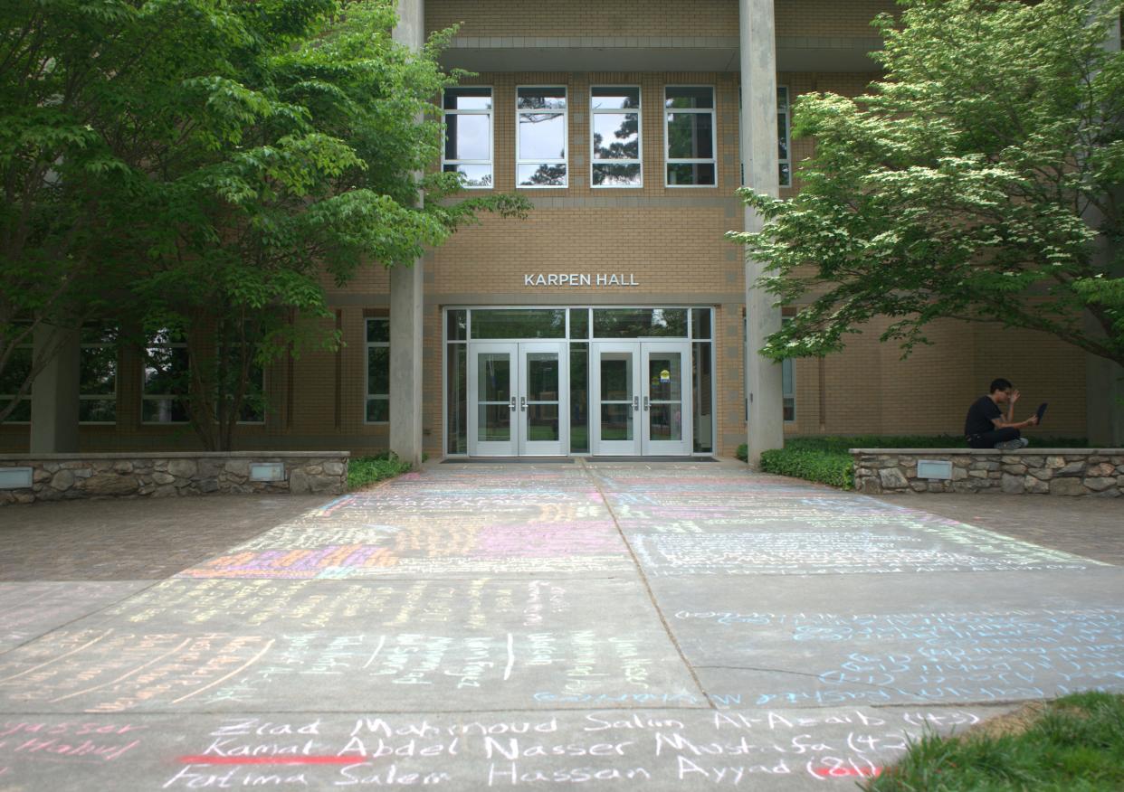 Names of Palestinian people killed in the Israel-Hamas war are written outside UNC Asheville's Karpen Hall, with "stop funding Israel" written right by the doors. Students are holding a "soft encampment" that started May 2.