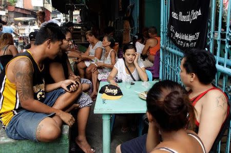 Jennelyn Olaires, 26, talks to her friends during the wake of her partner Michael Siaron in Pasay, Metro Manila, Philippines July 28, 2016. REUTERS/Czar Dancel