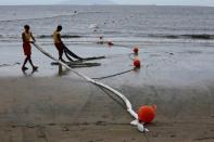 Beach guards collect oil absorbent strips on Cheung Sha beach at Lantau Island in Hong Kong, China August 9, 2017. REUTERS/Bobby Yip