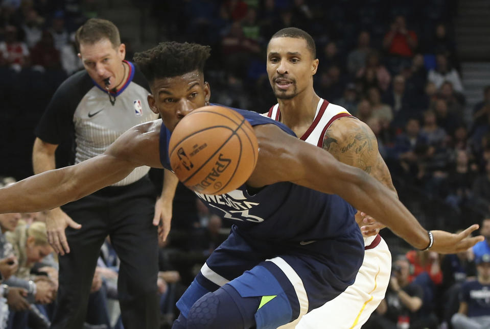 Minnesota Timberwolves' Jimmy Butler, left, chases the ball as Cleveland Cavaliers' George Hill looks on in the first half of an NBA basketball game Friday, Oct. 19, 2018, in Minneapolis. (AP Photo/Jim Mone)