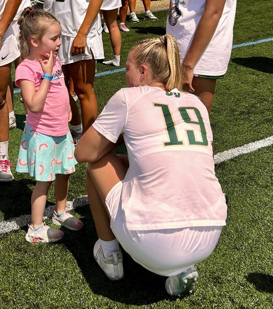 Jacksonville University graduate senior attack Mackenzie Boyle consoles Charlotte Donmoyer of Jacksonville after the Dolphins lost the ASUN women's lacrosse championship game on May 4 to Coastal Carolina. Charlotte and her family have forged a relationship with the JU team that began when JU adopted Charlotte's sister Lucy, who passed away in September of 2023, through Friends of Jaclyn, a program that connects college teams with pediatric cancer victims.