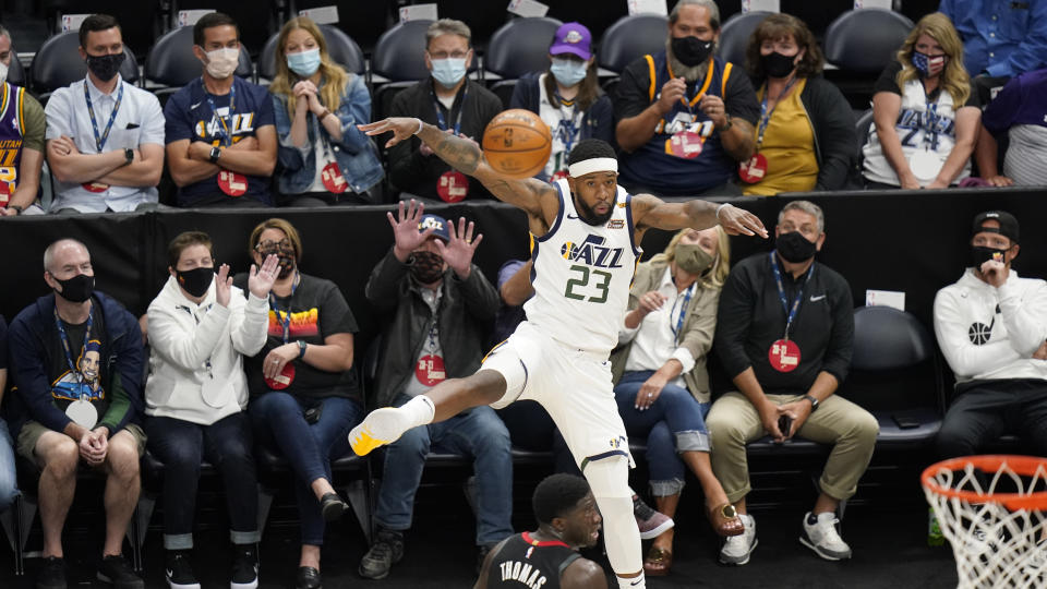 Utah Jazz forward Royce O'Neale (23) saves the ball as fans sitting courtside watch during the first half of the team's NBA basketball game against the Houston Rockets on Saturday, May 8, 2021, in Salt Lake City. (AP Photo/Rick Bowmer)