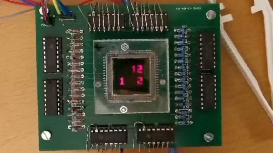 A green circuit board with a small basic display in the middle showing three red numbers