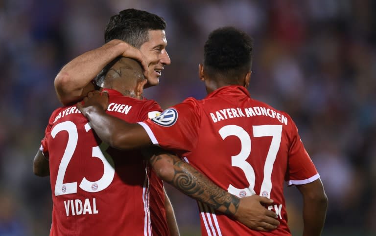 (From L) Bayern Munich's Arturo Vidal, Robert Lewandowski and Julian Green celebrate after scoring a goal during their German Cup (DFB Pokal) match against Carl Zeiss Jena, in Jena, eastern Germany, on August 19, 2016