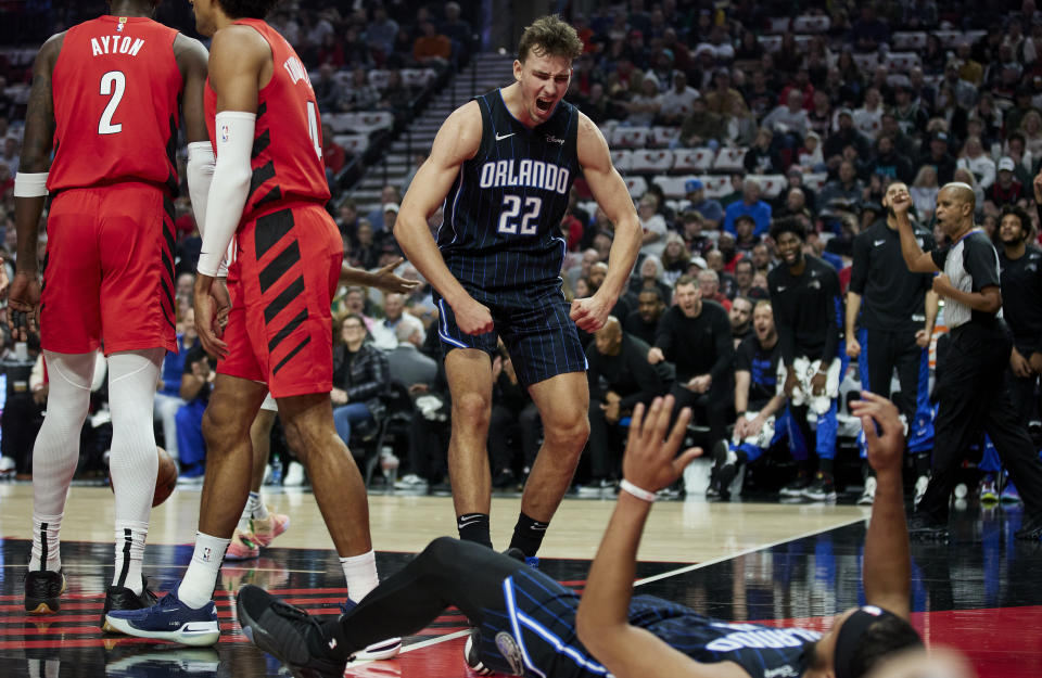 Orlando Magic forward Franz Wagner (22) reacts after a basket by guard Jalen Suggs, bottom right, during the first half of an NBA basketball game against the Portland Trail Blazers in Portland, Ore., Friday, Oct. 27, 2023. (AP Photo/Craig Mitchelldyer)