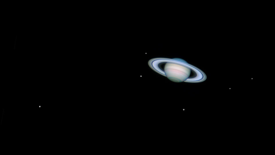  Saturn with six of it's moons hanging in space. 