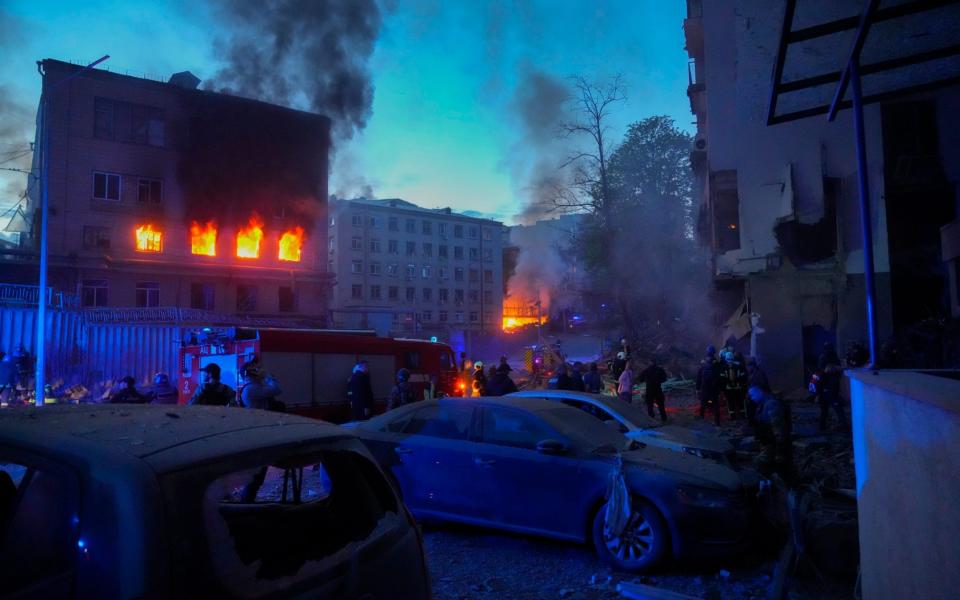 Firefighters put out a fire after a Russian rocket attack in Kyiv, Ukraine - Efrem Lukatsky/AP