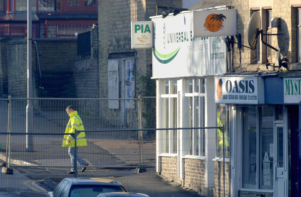 A metal fence is erected around Universal Express travel agents in Bradford, West Yorkshire, Monday November 21, 2005, near to where WPc Sharon Beshenivsky was shot dead by armed robbers on Friday. A sixth person arrested over the murder of the rookie police officer has been taken to Yorkshire for questioning, police said today. See PA story POLICE Officer. PRESS ASSOCIATION photo. Photo credit should read: John Giles/PA.