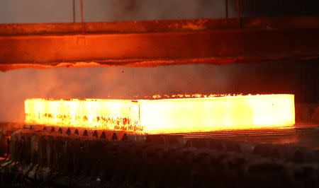 Flames rolls off a slab of steel as it rolls down the line at the Novolipetsk Steel PAO steel mill in Farrell, Pennsylvania, U.S., March 9, 2018. REUTERS/Aaron Josefczyk