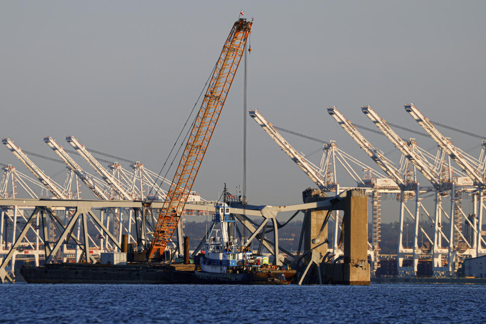 Cranes stand by as the wreckage of the Francis Scott Key Bridge rests on the container ship Dali, Saturday, March 30, 2024, in Baltimore. (AP Photo/Julia Nikhinson)