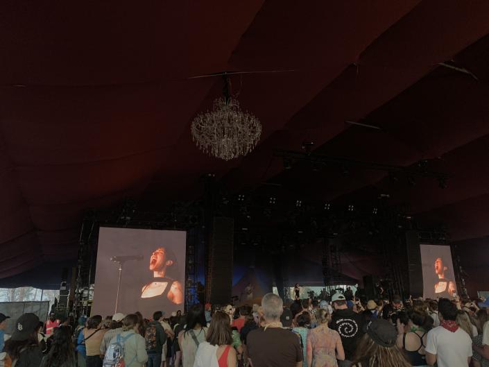 Caroline Polachek performing on stage in a covered venue at Coachella