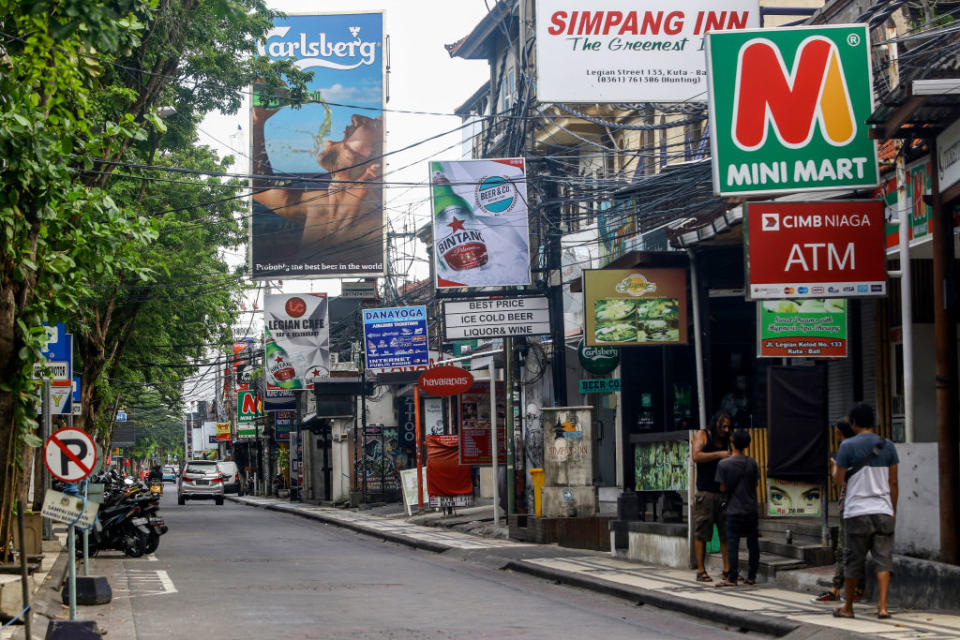 A number of residents are in front of a closed bar in Kuta Bali. 